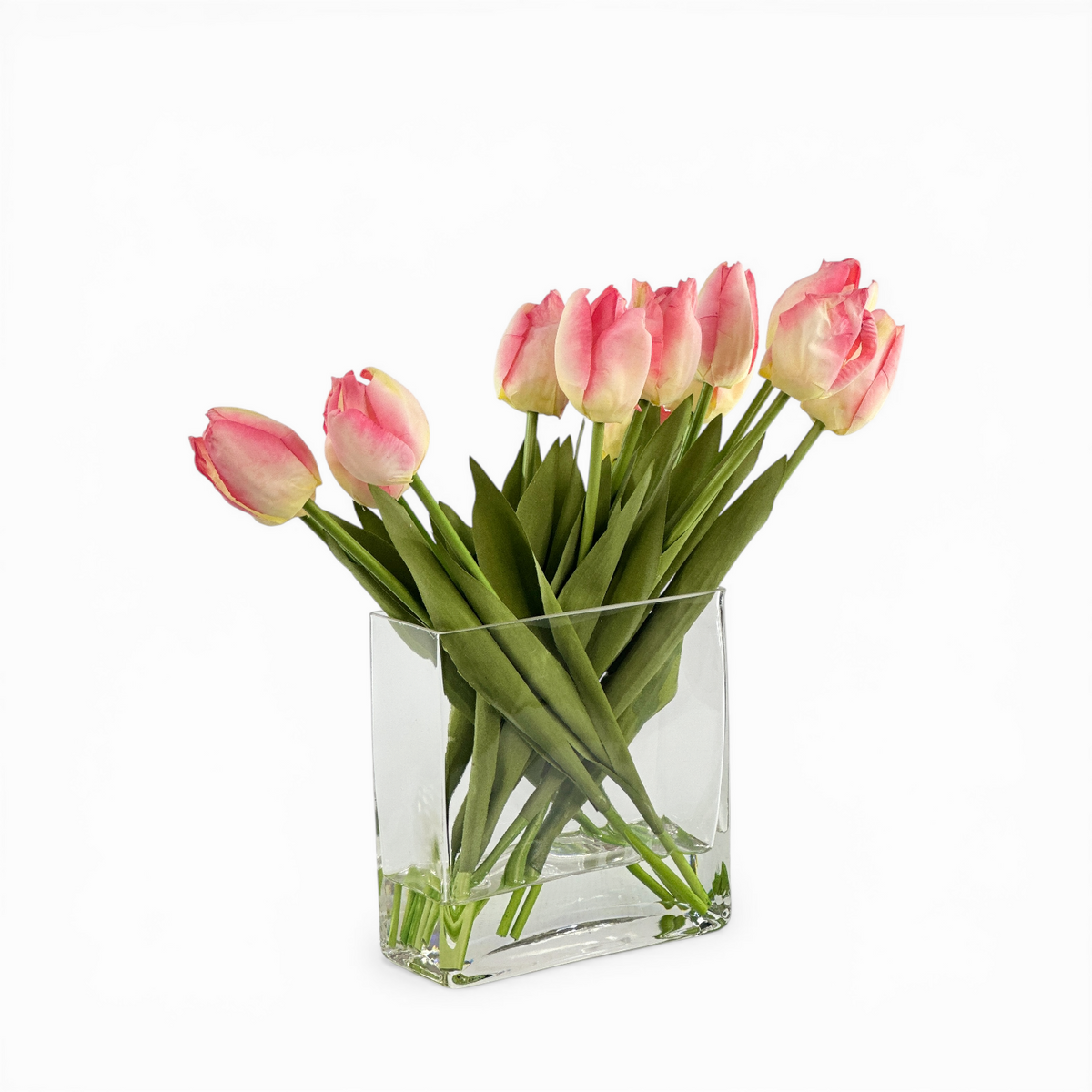 Clear glass vase with  faux. pink tulips on a white background