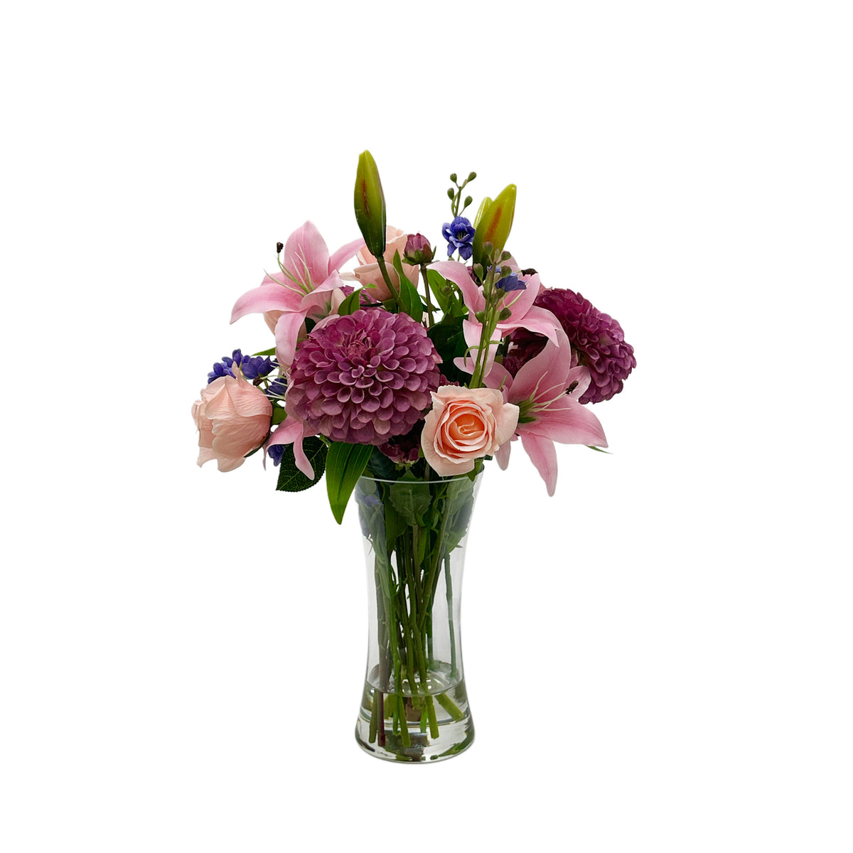 Bouquet of Faux flowers in a clear vase on a white background, including Dahlia lily and roses in ink and Purple