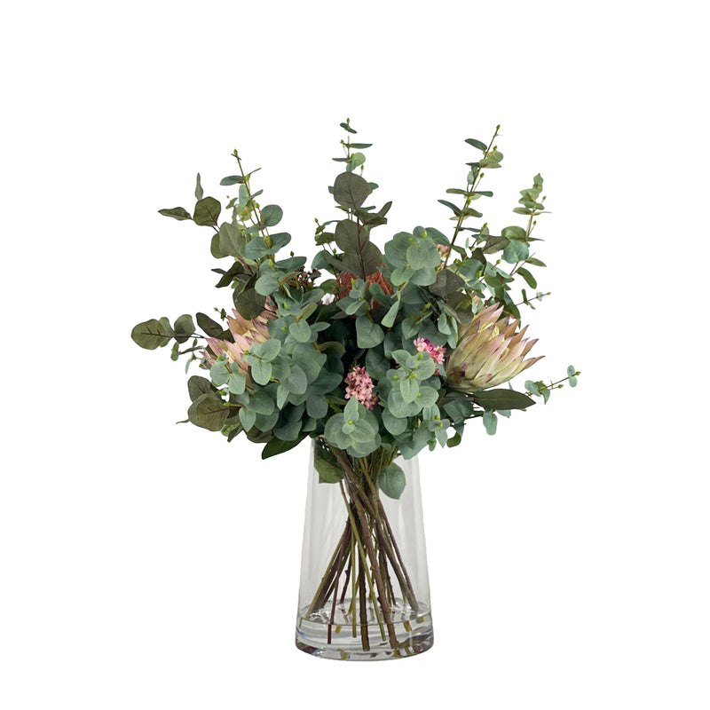 Bouquet of faux Protea pincusion and Eucaluptus with a clear vase with faux water on a white background