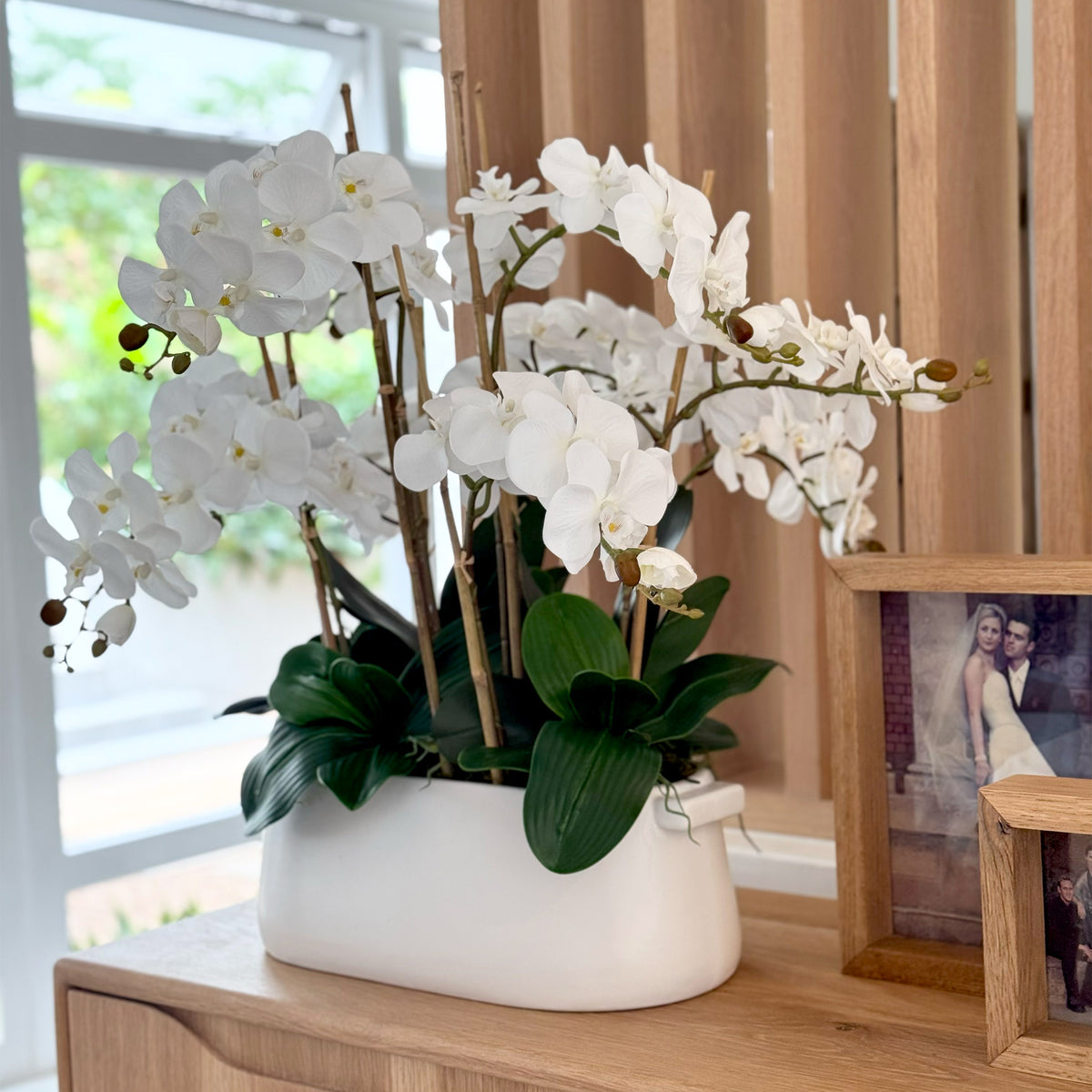 Artificial Palaenopsis Arrangement in chic white oval ceramic pot 66cm high 85cm wide in beautiful setting on console table