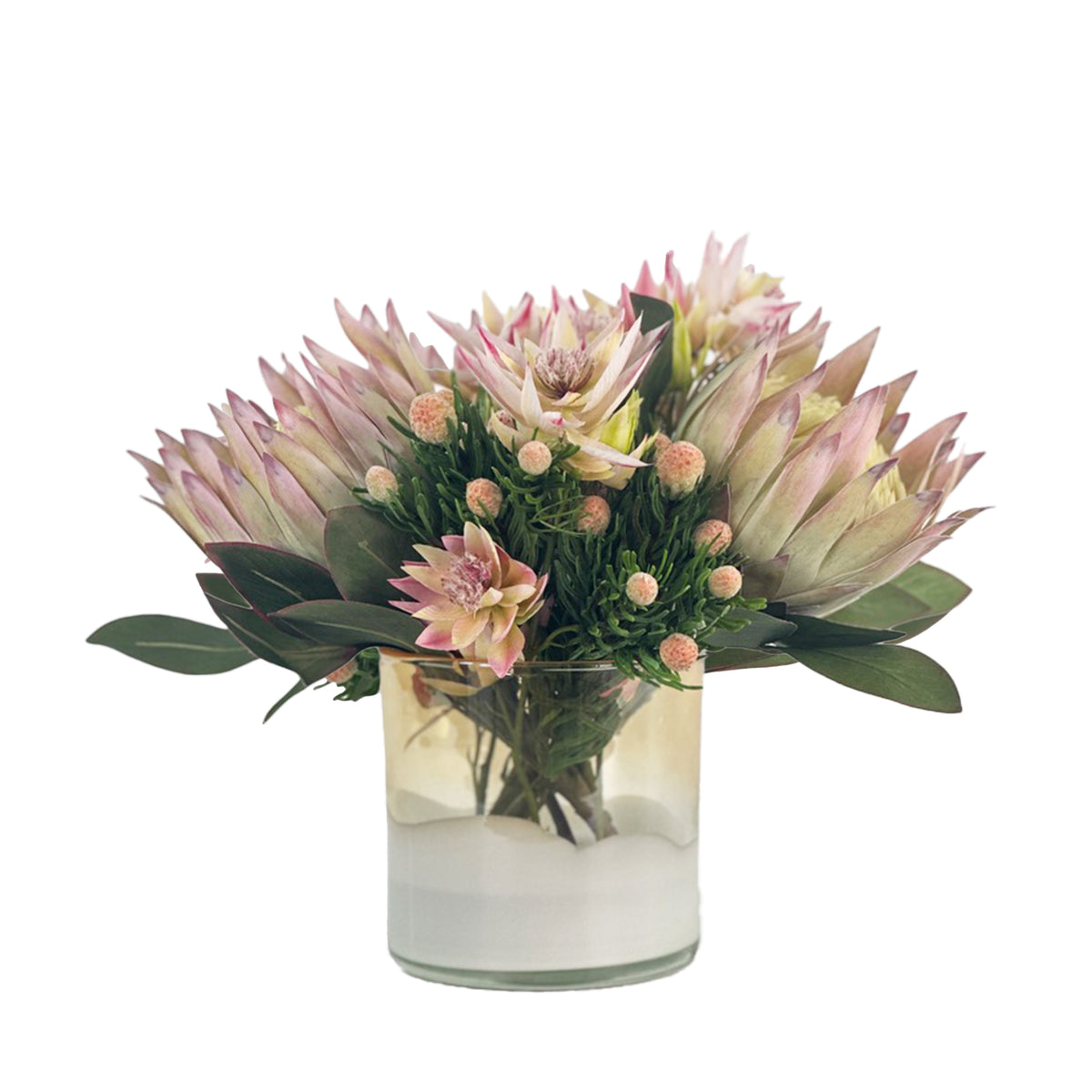 Artificial protea arrangement brings soft blush-pink blooms, tiny buds, and green leaves together in a clean glass cylinder set with faux water
