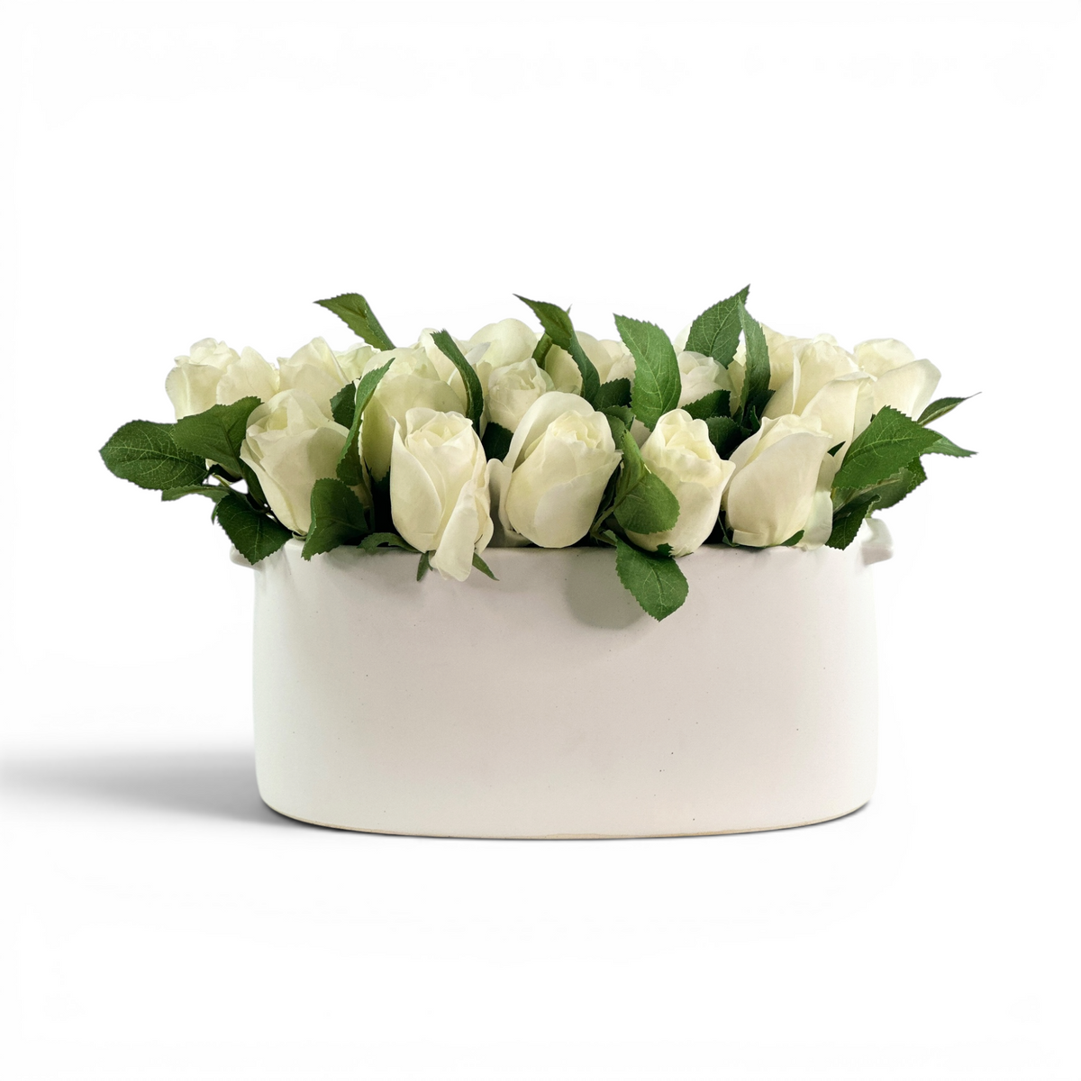 White faux rosebuds set in a white ceramic planter
