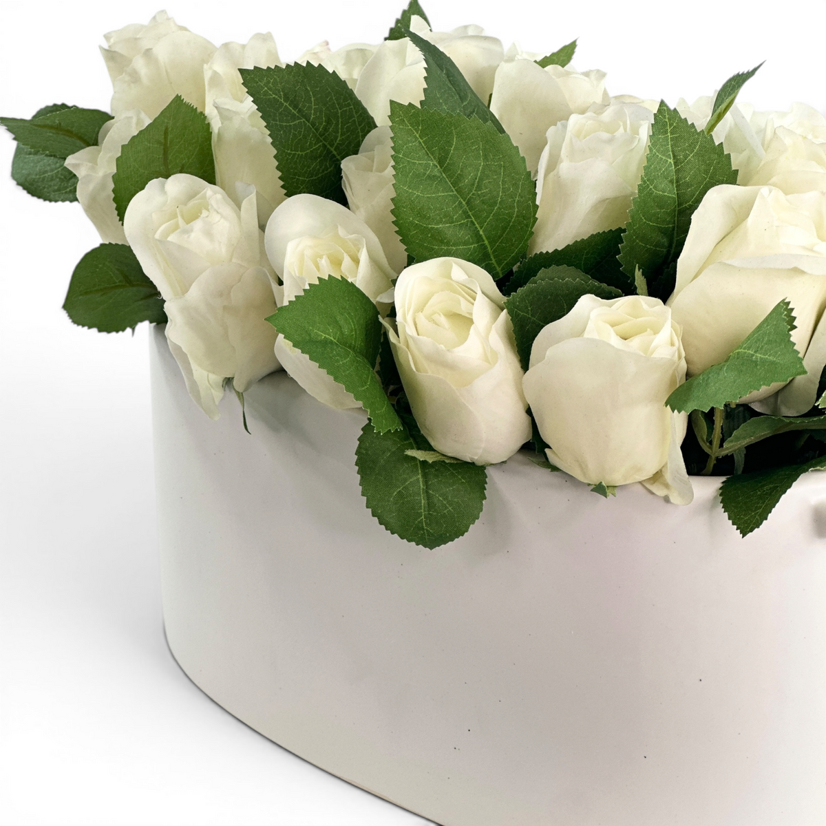 White faux rosebuds set in a white ceramic planter