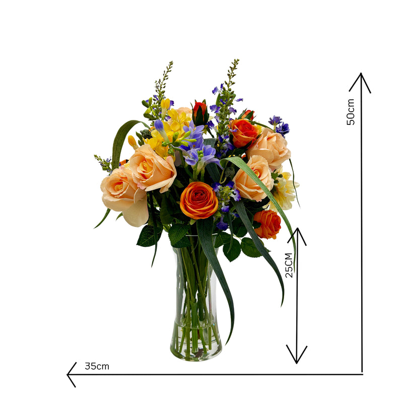 Bouquet of faux flowers in a clear vase with dimensions indicated on a white background. including oses Freesia and dahlia