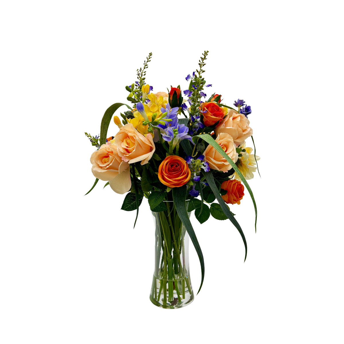 Bouquet of colorful faux flowers in a clear vase on a white background