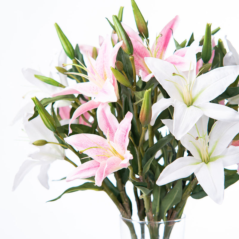 Close up of Flowers and stems of Artificial Pink and White Lily Arrangement in faux water